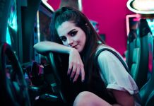 woman sitting on car arcade machine