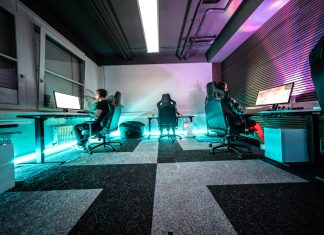 A group of people sitting around a computer desk
