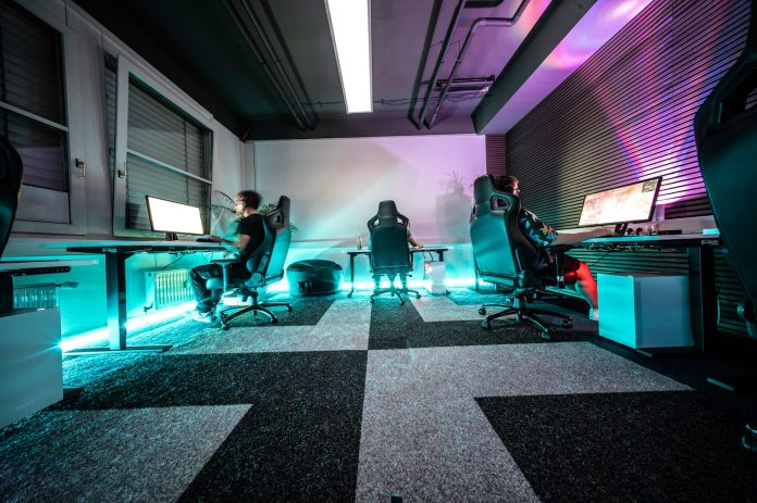 A group of people sitting around a computer desk