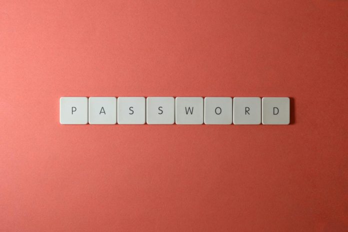 Focus on password security with white keyboard tiles spelling 'PASSWORD' on a coral background.